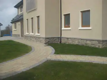 Rendered house with stone cladding around the base in the Ridge Stone Ambleside profile